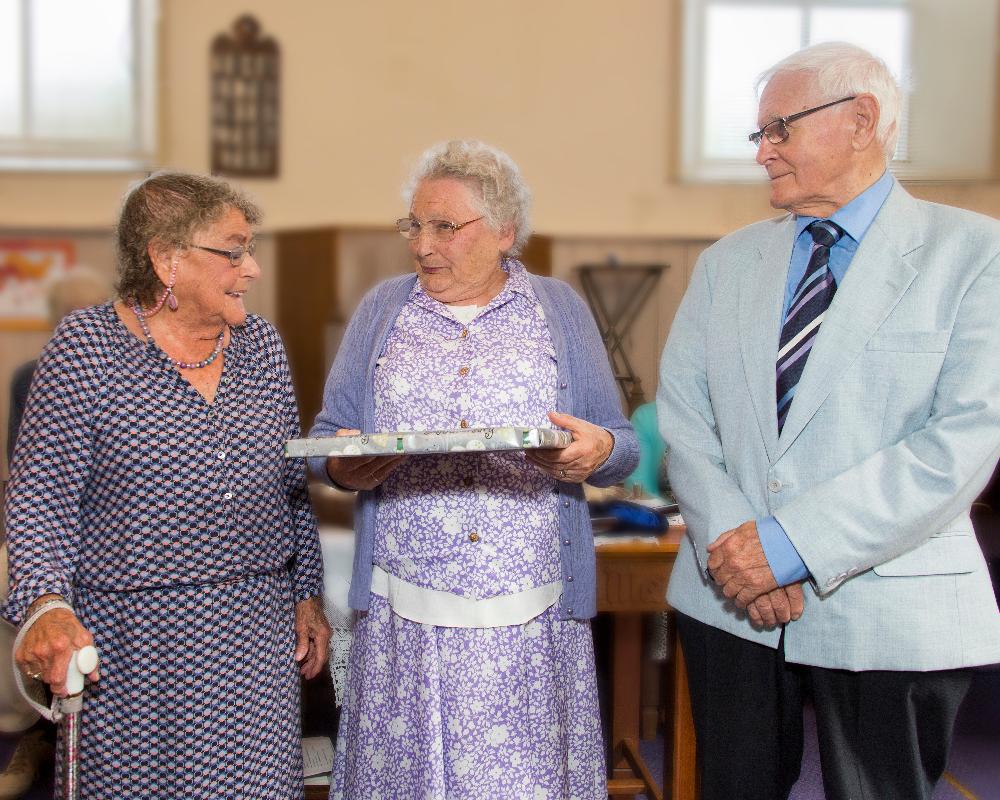 Enid Parsons presenting Denis and Kate King with a framed print
